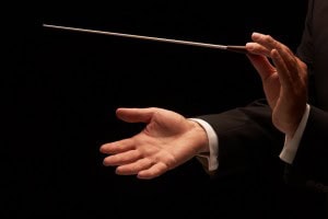 Conductor conducting an orchestra isolated on black background